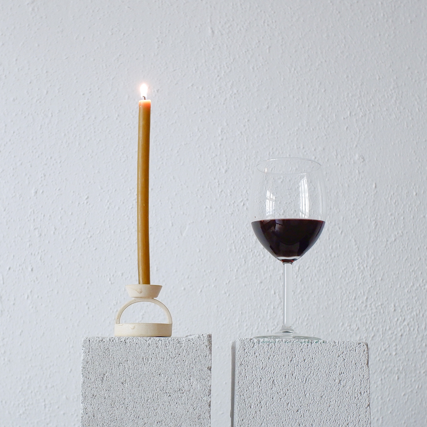 Cup of Wine and a Ceramic Porcelain Candle Holder with a Lit Candle